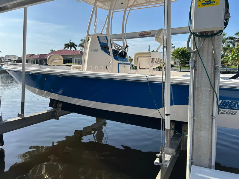 Slide: The Image of 2019 Pathfinder 2200 CC boat in blue, docked on a lift by the water. - 3