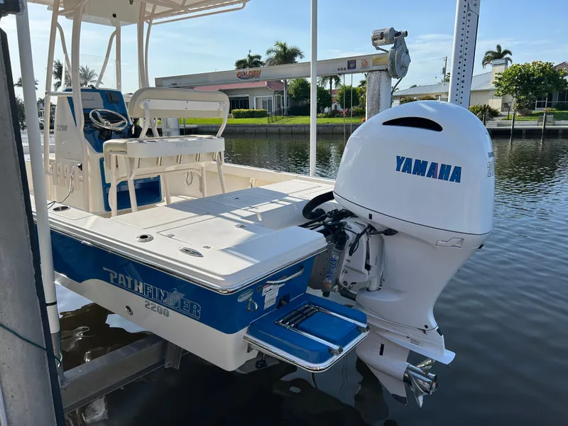 Slide: The Image of 2019 Pathfinder 2200 CC boat with Yamaha outboard motor docked by the water. - 4