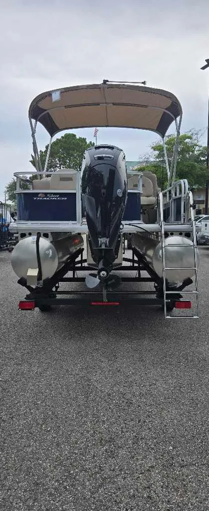 Slide: The Image of 2025 Sun Tracker Bass Buggy 18 DLX pontoon boat, rear view with canopy and motor. - 4