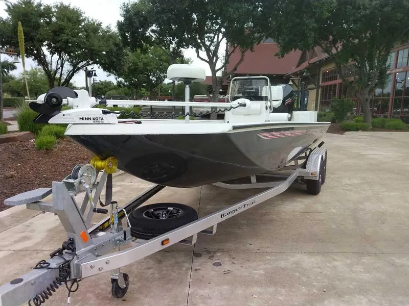 Slide: The Image of 2025 Ranger RB210 boat on trailer, featuring Minn Kota Terrova motor, parked outdoors. - 0