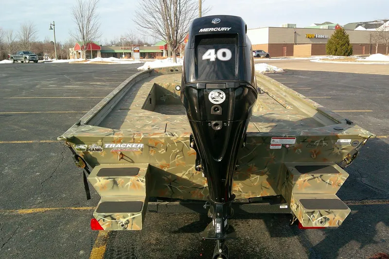 Slide: The Image of 2025 Tracker Grizzly 1654 T Sportsman boat with Mercury 40 engine in a parking lot. - 5