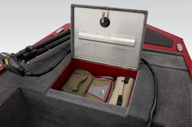 Slide: The Image of 2025 Tracker Panfish 17 boat storage compartment with carpeted interior and metal latch. - 12