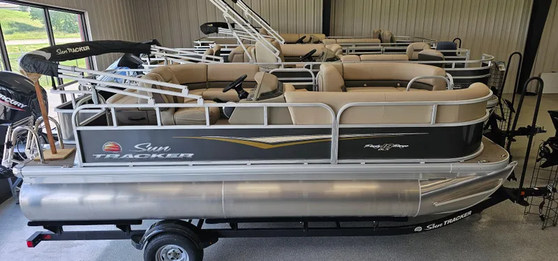 The Image of 2025 Sun Tracker Party Barge 18 DLX pontoon boat in showroom, side view. - 0
