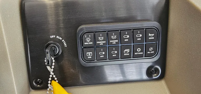 Slide: The Image of Control panel of 2025 Sun Tracker Party Barge 18 DLX with ignition and accessory switches. - 11