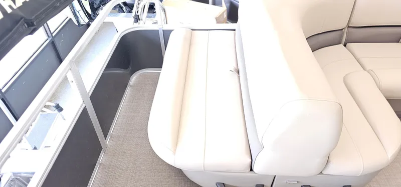 Slide: The Image of 2025 Sun Tracker Party Barge 18 DLX interior with beige seating and gray flooring. - 13
