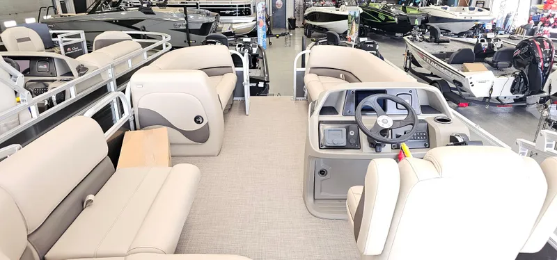 Slide: The Image of 2025 Sun Tracker Party Barge 18 DLX interior with beige seating and steering console. - 14