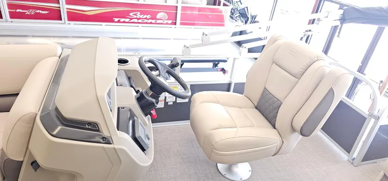 Slide: The Image of 2025 Sun Tracker Party Barge 18 DLX interior with beige captain's chair and steering console. - 7