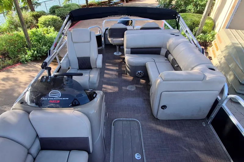 Slide: The Image of 2023 Sun Tracker SportFish 22 XP3 pontoon boat interior with plush seating and helm. - 13