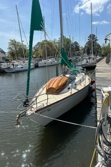 The Image of 1978 Tartan 37 sailboat docked in a marina, featuring green sails and a wooden deck. - 0