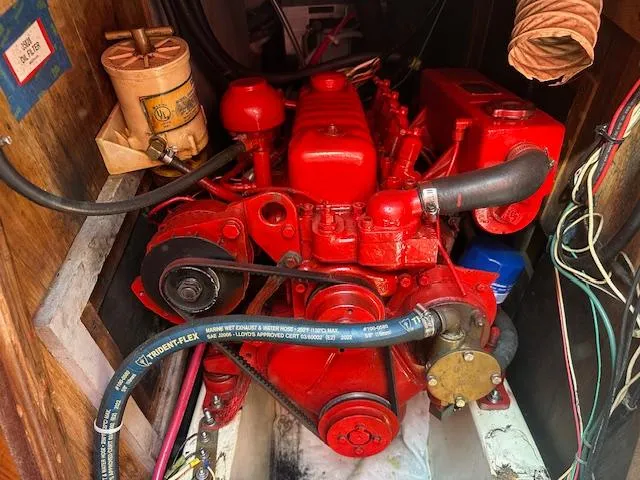 Slide: The Image of Red engine inside a 1978 Tartan 37 sailboat, featuring hoses and mechanical components. - 10