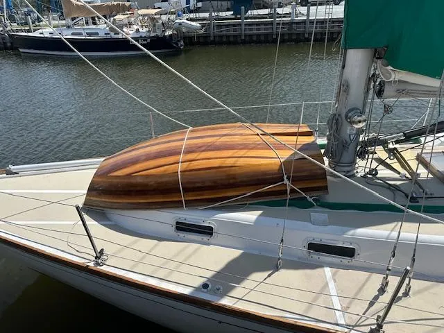 Slide: The Image of 1978 Tartan 37 sailboat with wooden dinghy on deck, docked in a marina. - 3