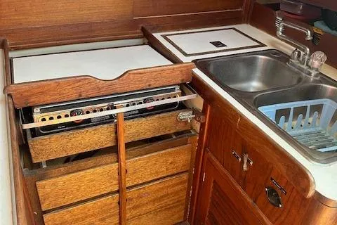 Slide: The Image of 1978 Tartan 37 yacht kitchen with wooden cabinetry, stove, and stainless steel sink. - 4