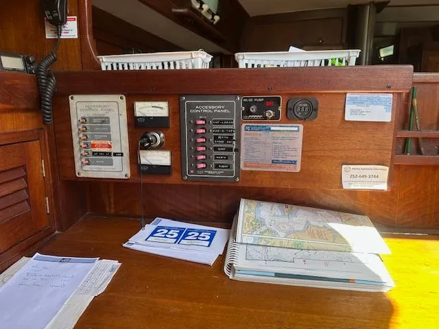 Slide: The Image of Control panel and navigation charts inside a 1978 Tartan 37 sailboat cabin. - 5