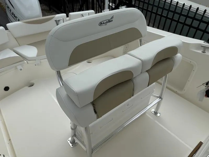 Slide: The Image of 2025 Bulls Bay 230 Center Console boat seating area with cushioned seats and storage. - 10