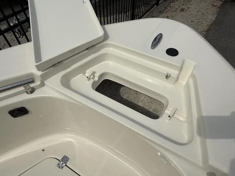 Slide: The Image of 2025 Bulls Bay 230 Center Console boat storage compartment, open lid, beige interior. - 7