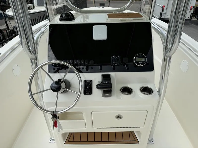Slide: The Image of 2025 Bulls Bay 230 Center Console boat dashboard with steering wheel and controls. - 8