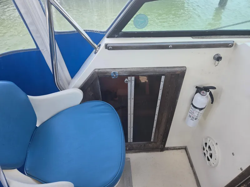 Slide: The Image of 1989 Parker 2310 Walkaround interior with blue seating, fire extinguisher, and cabin door. - 7