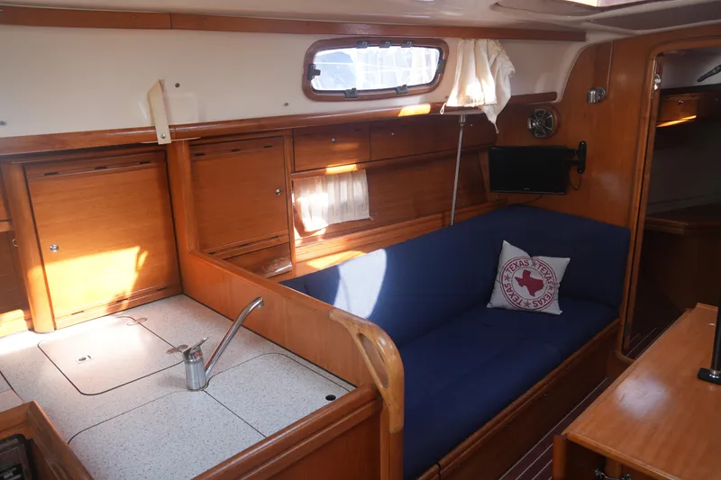 Slide: The Image of Interior of 2007 Bavaria 37 Cruiser yacht with blue seating and wooden cabinetry. - 21