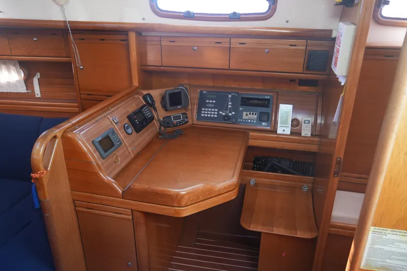 Slide: The Image of 2007 Bavaria 37 Cruiser navigation station with wooden cabinetry and control panels. - 22
