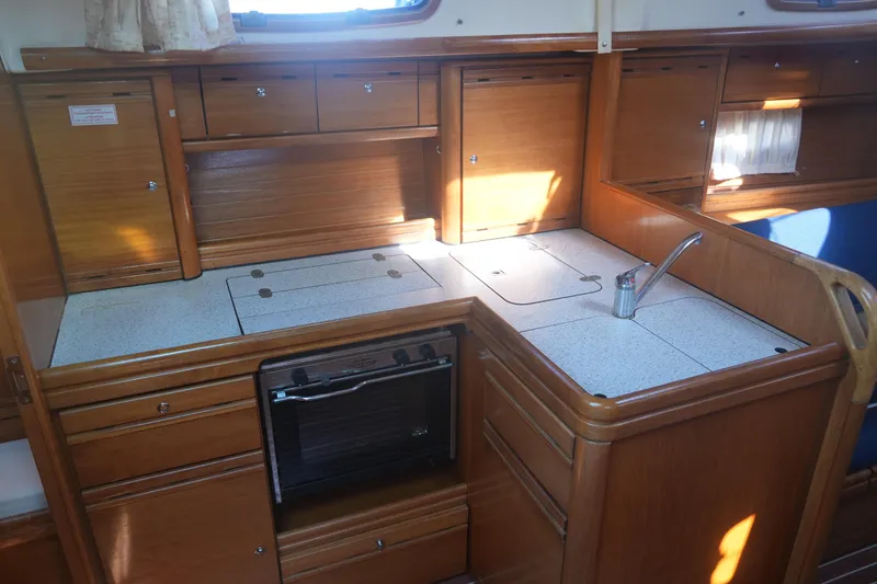 Slide: The Image of Interior of 2007 Bavaria 37 Cruiser yacht kitchen with wooden cabinets and compact design. - 23