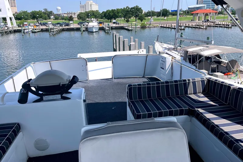 Slide: The Image of 1999 Jefferson Marquessa 56 yacht deck with striped seating, docked at a marina. - 11