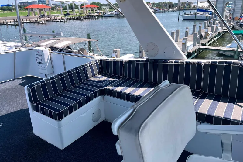 Slide: The Image of 1999 Jefferson Marquessa 56 yacht with striped seating, docked at a marina. - 13