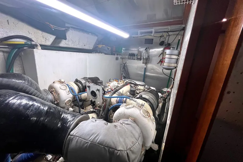 Slide: The Image of Engine room of a 1999 Jefferson Marquessa 56 yacht, featuring complex machinery and piping. - 24