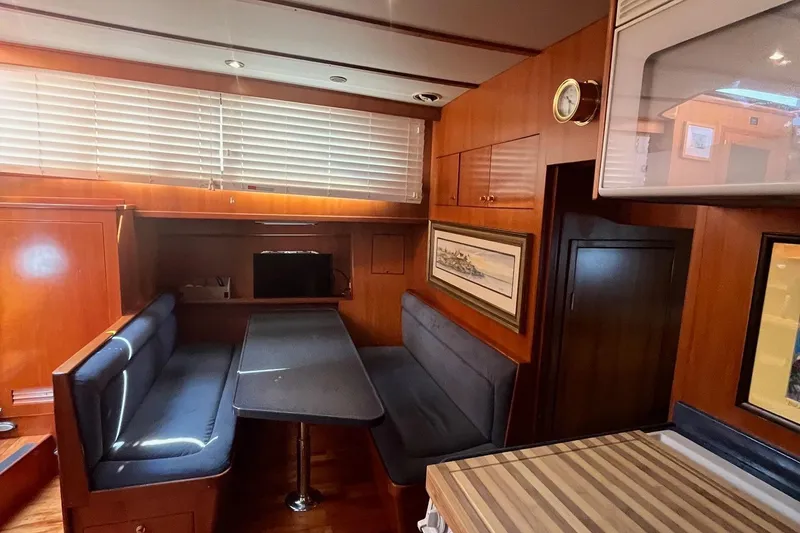 Slide: The Image of Interior of 1999 Jefferson Marquessa 56 yacht with wood paneling and cozy seating area. - 48