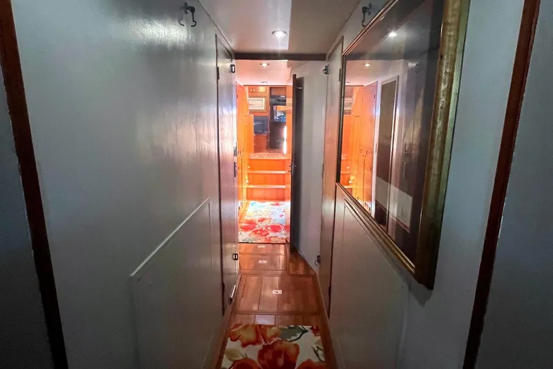 Slide: The Image of Hallway inside 1999 Jefferson Marquessa 56 yacht, featuring wooden flooring and floral carpet. - 66
