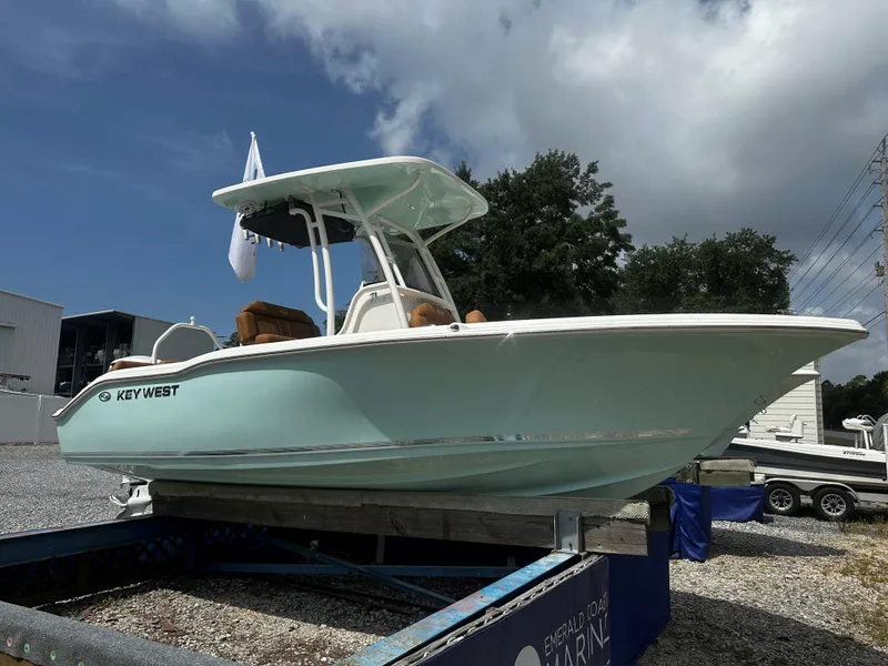 The Image of 2025 Key West 219fs boat on display, light blue hull, outdoor setting, partly cloudy sky. - 1