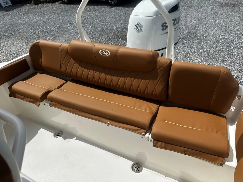 Slide: The Image of 2025 Key West 219fs boat with brown leather seating and Suzuki engine in background. - 10