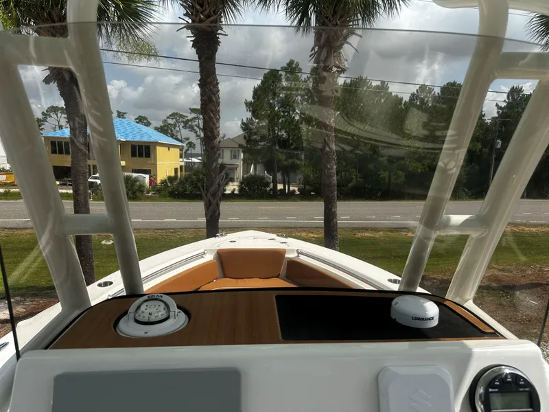 Slide: The Image of 2025 Key West 219fs boat dashboard with palm trees and houses in the background. - 6