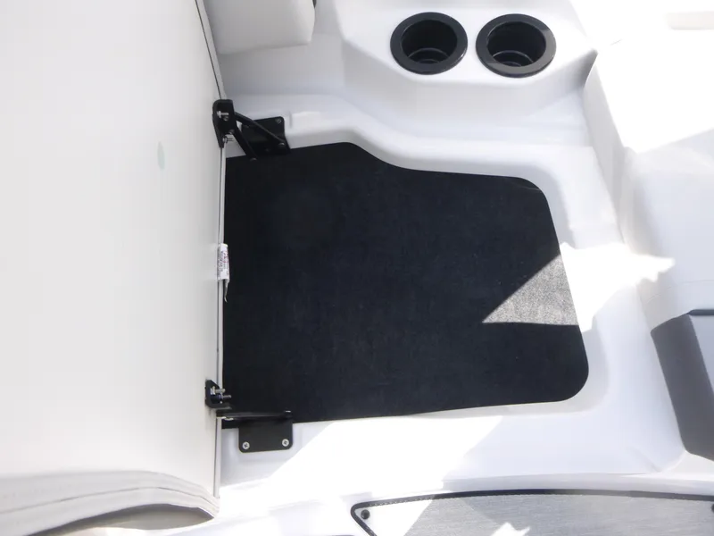 Slide: The Image of 2025 Yamaha Boats AR220 interior with black mat and cup holders. - 10