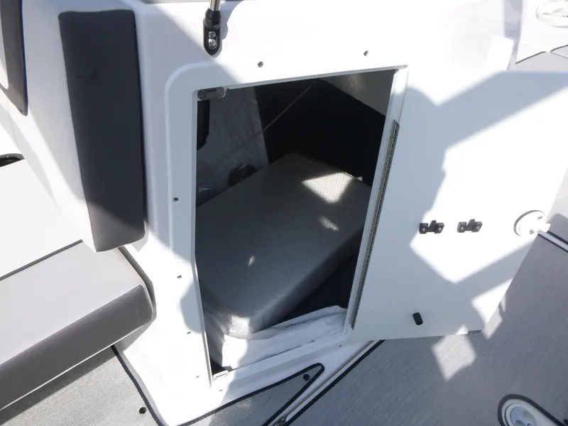 Slide: The Image of 2025 Yamaha AR220 boat storage compartment with open door, showcasing interior space. - 13