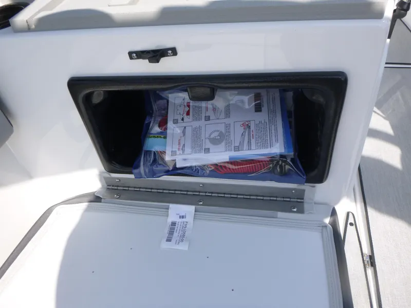 Slide: The Image of Storage compartment on a 2025 Yamaha Boats AR220, containing manuals and equipment. - 9