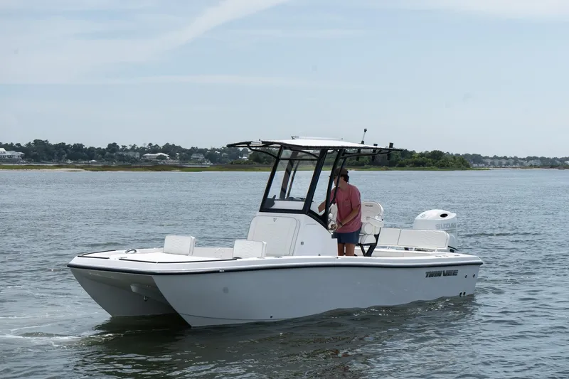 The Image of 2026 Twin Vee 22 Baycat boat cruising on calm waters with a person onboard. - 0