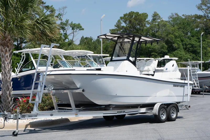 Slide: The Image of 2026 Twin Vee 22 Baycat boat on trailer, parked outdoors. - 13