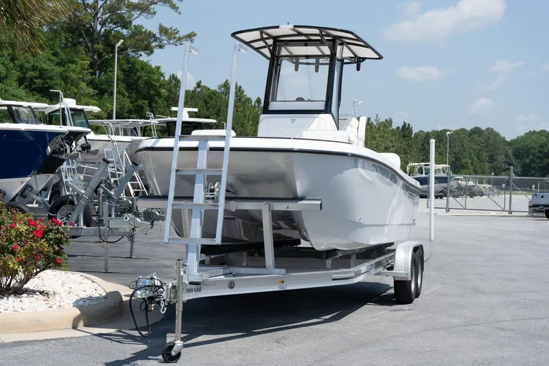 Slide: The Image of 2026 Twin Vee 22 Baycat boat on trailer in sunny outdoor setting. - 14