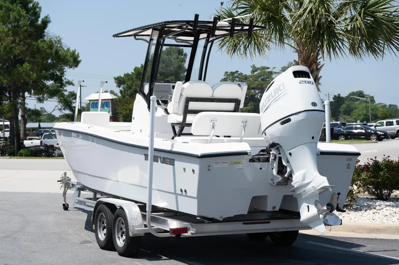 Slide: The Image of 2026 Twin Vee 22 Baycat boat on trailer, parked outdoors near palm trees. - 16