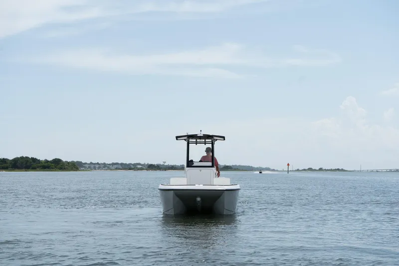 Slide: The Image of 2026 Twin Vee 22 Baycat boat cruising on calm waters under a clear sky. - 2