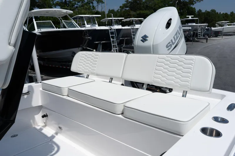 Slide: The Image of 2026 Twin Vee 22 Baycat boat with white cushioned seating and Suzuki outboard motor. - 20