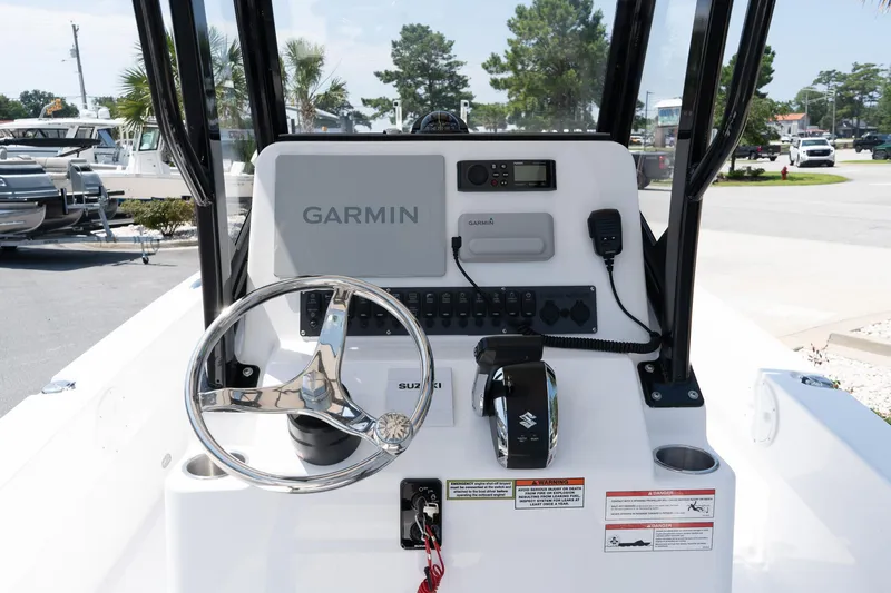 Slide: The Image of 2026 Twin Vee 22 Baycat boat dashboard with Garmin navigation system and steering wheel. - 22
