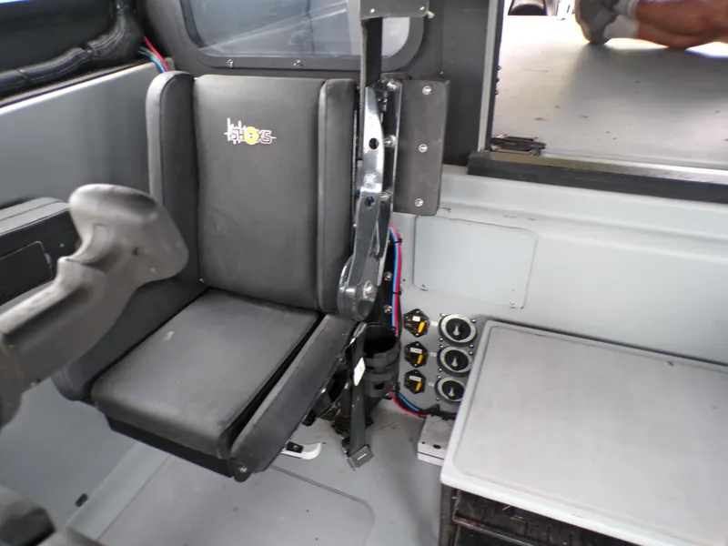 Slide: The Image of Interior of a 2001 Custom Revenge 50 boat, featuring a black seat and control panel. - 11