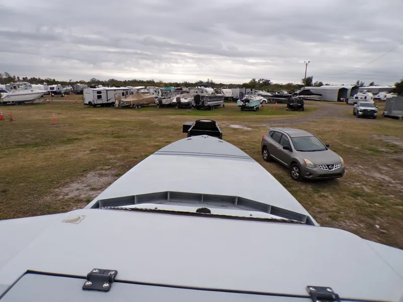 Slide: The Image of 2001 Custom Revenge 50 boat in storage yard with vehicles and trailers. - 13