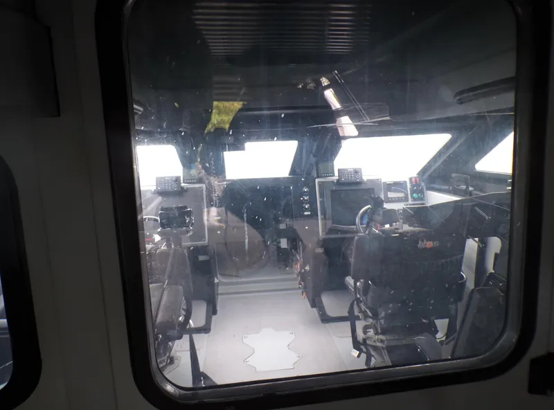 Slide: The Image of Interior view of a 2001 Custom Revenge 50 boat cockpit through a window. - 15