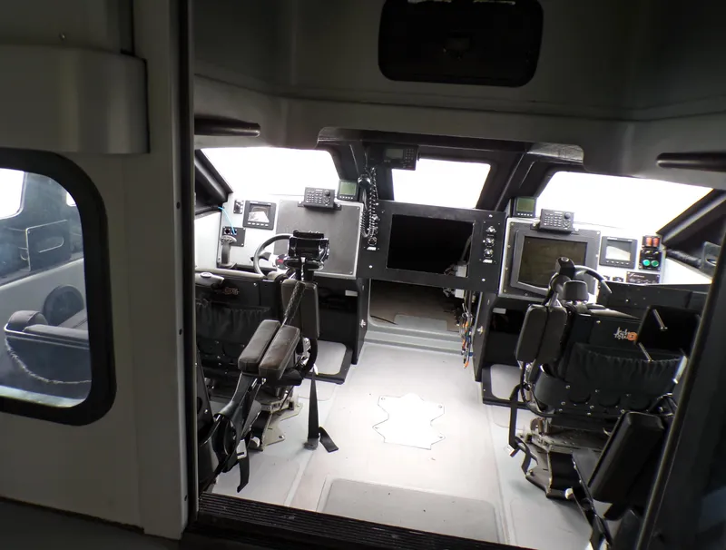 Slide: The Image of Interior cockpit of 2001 Custom Revenge 50 boat, featuring advanced navigation equipment and seating. - 17