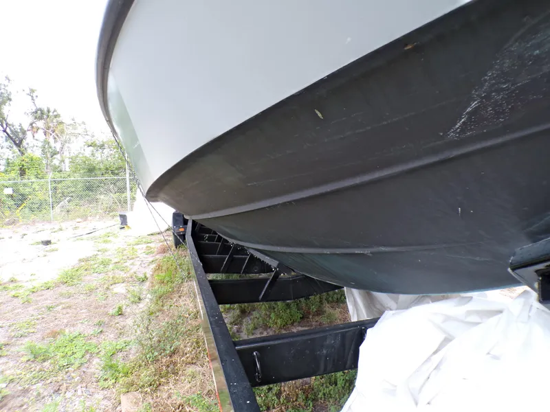 Slide: The Image of Custom Revenge 50 boat from 2001 on a trailer, showing hull and outdoor setting. - 23