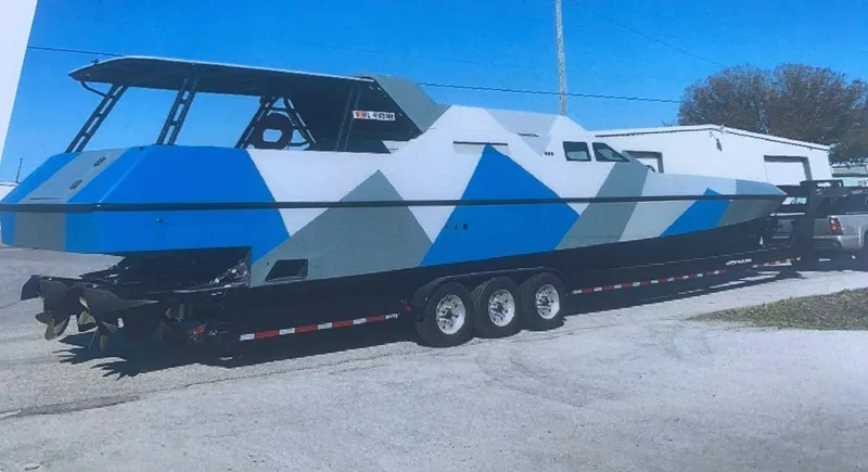 Slide: The Image of Custom Revenge 50 boat, 2001 model, with geometric blue and gray design on a trailer. - 29