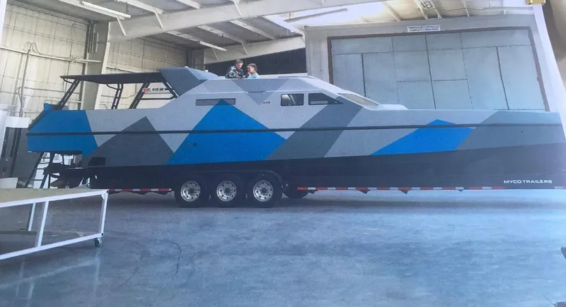 Slide: The Image of Custom Revenge 50 boat, 2001 model, in a warehouse with geometric blue and gray design. - 30