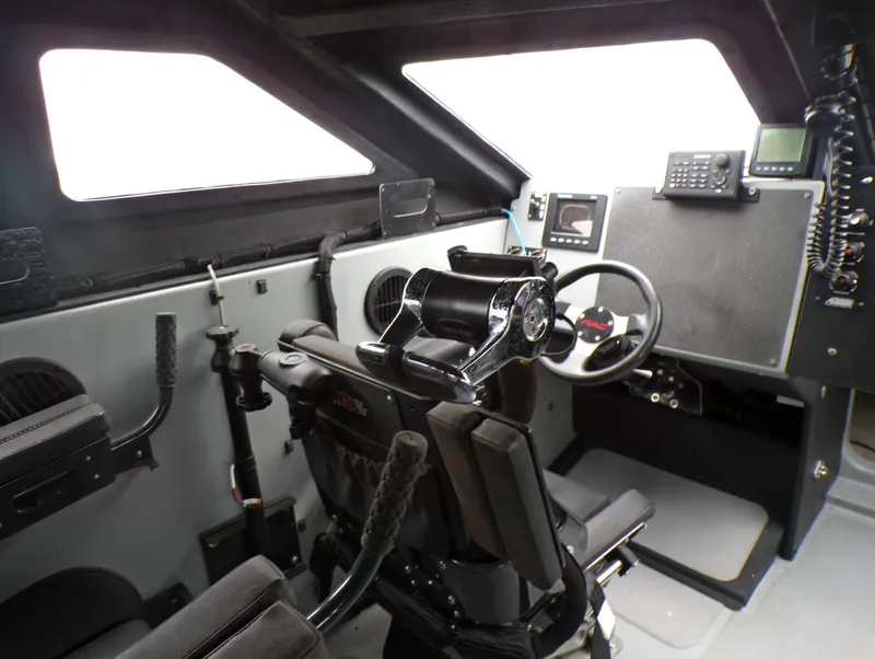 Slide: The Image of Interior of a 2001 Custom Revenge 50 boat cockpit with steering wheel and control panel. - 7